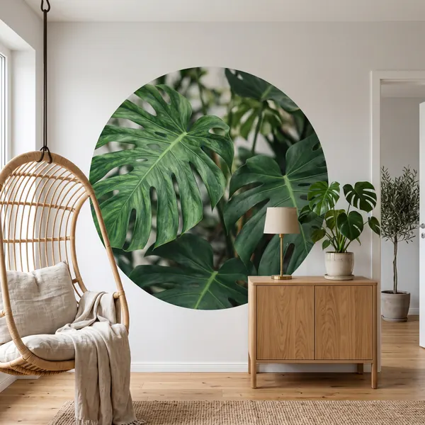 Selbstklebender Tapetenkreis mit Monstera-Blättern an der Wand neben einem Hängesessel