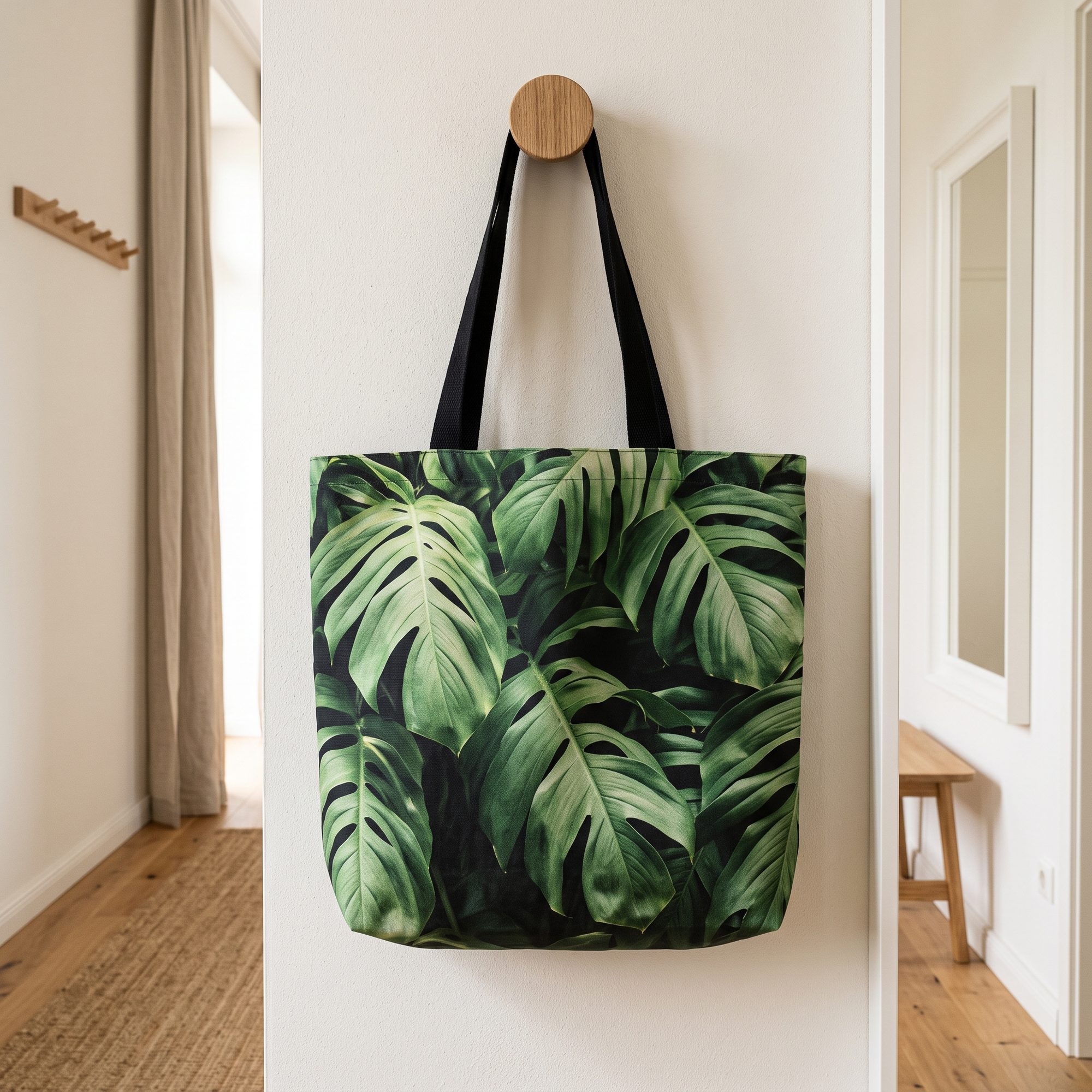 Stofftasche mit Monstera-Fotodruck an einem Wandhaken im Flur